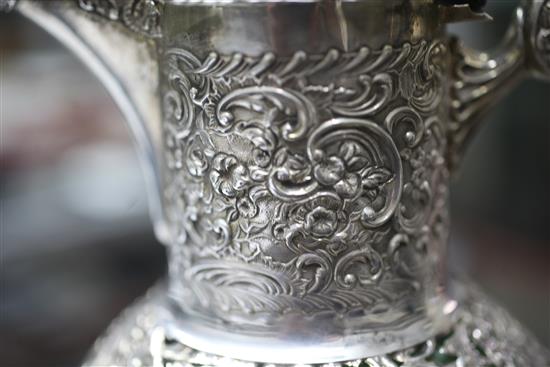 A late Victorian pierced repousse silver mounted green and clear cut glass claret jug by William Comyns, London, 1897, 26cm.